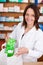 Female Pharmacist Putting Medicine Package In Bag At Counter
