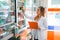 female pharmacist in uniform working checking medicine by observing