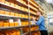 Female pharmacy worker looking at shelves for drugs and medicine