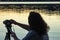 Female photographer in shadow looking out at water of the puget sound