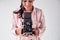 Female Photographer With Vintage Medium Format Camera On Photo Shoot Against White Studio Backdrop