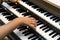 A female pianist plays a three- manual electronic organ