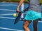 Female pickleball player hitting the ball with her paddle
