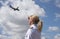 Female pilot with a passing passenger jet in sky