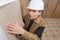 Female plasterer installing material on wall