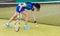Female player picks up a tennis ball on a court