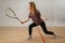 Female player with squash racket in action