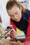 Female plumber using tablet while working on boiler