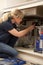 Female Plumber Working On Sink