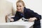 Female Plumber Working On Sink Using Wrench