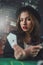 Female poker player beautifully dressed with exquisite perfume with cards in hands at the casino table