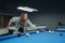female pool player poking the billiard ball seriousely