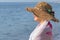 Female portrait in profile, a slender woman, middle-aged, 50 years old, in a straw hat,