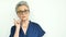 Female portrait of serious grandmother with grey hair and face with wrinkles wearing eyeglasses on white background