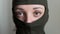 Female portrait of young girl wearing khaki balaclava, only eyes are visible, mandatory conscription, military, feminism