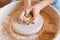 Female potter shaping a pot on pottery wheel