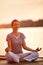 Female practicing yoga near river