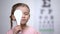 Female preschooler closing eye for complete vision exam, diagnostics of sight