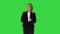 Female presenter blond woman walking and pointing to the sides on a Green Screen, Chroma Key.