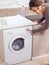 Female pressing button on washing machine
