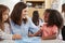 Female primary school teacher and girls in class, close up