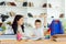 Female private tutor helping young student with homework at desk in bright child`s room