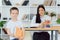 Female private tutor helping young student with homework at desk in bright child`s room