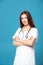 Female profession. Good family, children`s, woman pediatrician or nurse with a stethoscope isolated on a blue background. Concept