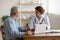 Female professional doctor explaining geriatric disease treatment to senior patient