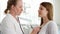 Female professional doctor at work. Woman physician using stethoscope for listening patient`s lungs