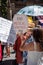 A female protestor is holding a homemade anti government banner