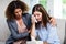 Female psychologist consoling depressed woman on sofa at home