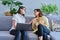 Female psychologist and middle aged woman patient sitting together on couch in office