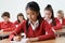 Female Pupil At Desk Taking School Exam