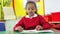 Female Pupil Reading Book At Table