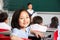 Female Pupil Working At Desk In Chinese School