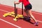 Female pushes a yellow sled on a track at practice