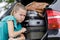 female pushing luggage in car trunk