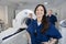 Female Radiologist With Colleagues Standing By MRI Machine