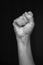 Female raised fist isolated on black background