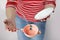 A female in red and white stripy shirt dropping teacup with tea and spoon