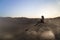 Female relaxing on the sand dune, admiring the oasis town of Huacachina, Ica, Peru.The sunset desert view