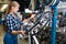 Female is replacing wheels of bicycle with another one in workshop.