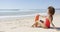 Female with rescue float sitting on beach