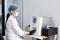 Female Research Scientist Putting Test Tube with Blood Sample into Analyzer Medical Machine. Scientist Works with Modern