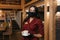 A female restaurant manager who wears a face mask is holding a cup of coffee