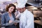 Female restaurant manager writing on clipboard while interacting to head chef