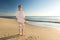 Female retiree standing at the beach and looking towards the ocean