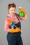 Female retro make-up with spray in hand. Denim girl cleaning with spray and duster in studio on grey background