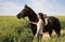 A female riding on a black horse